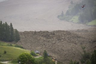 A large avalanche with a mixture of ice, rock, snow and water reach the valley floor is pictured in Wiler after the Birch glacier collapsing above Blatten, Switzerland, Wednesday, May 28, 2025. A large part of the village of Blatten in the Valais Loetschental was buried under the masses of ice, mud and rock. Numerous houses were destroyed, but no people were harmed. On the Kleiner Nesthorn above Blatten, several million cubic metres of rock collapsed between 19 and 28 May. A nine million tonne cone of rubble formed on the Birch Glacier below, which broke on 28 May 2025. (KEYSTONE/Jean-Christophe Bott)